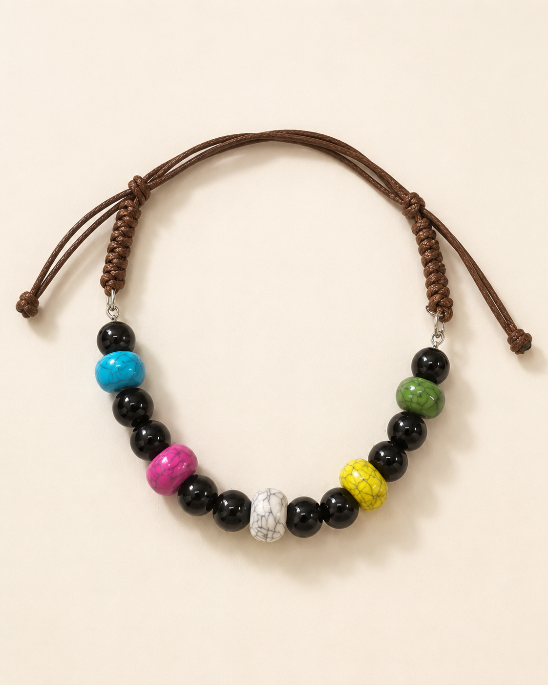 A beaded necklace with a brown adjustable cord, featuring black beads, a bright blue bead, a pink bead, a yellow marbled bead, a green bead, and a white marbled bead.