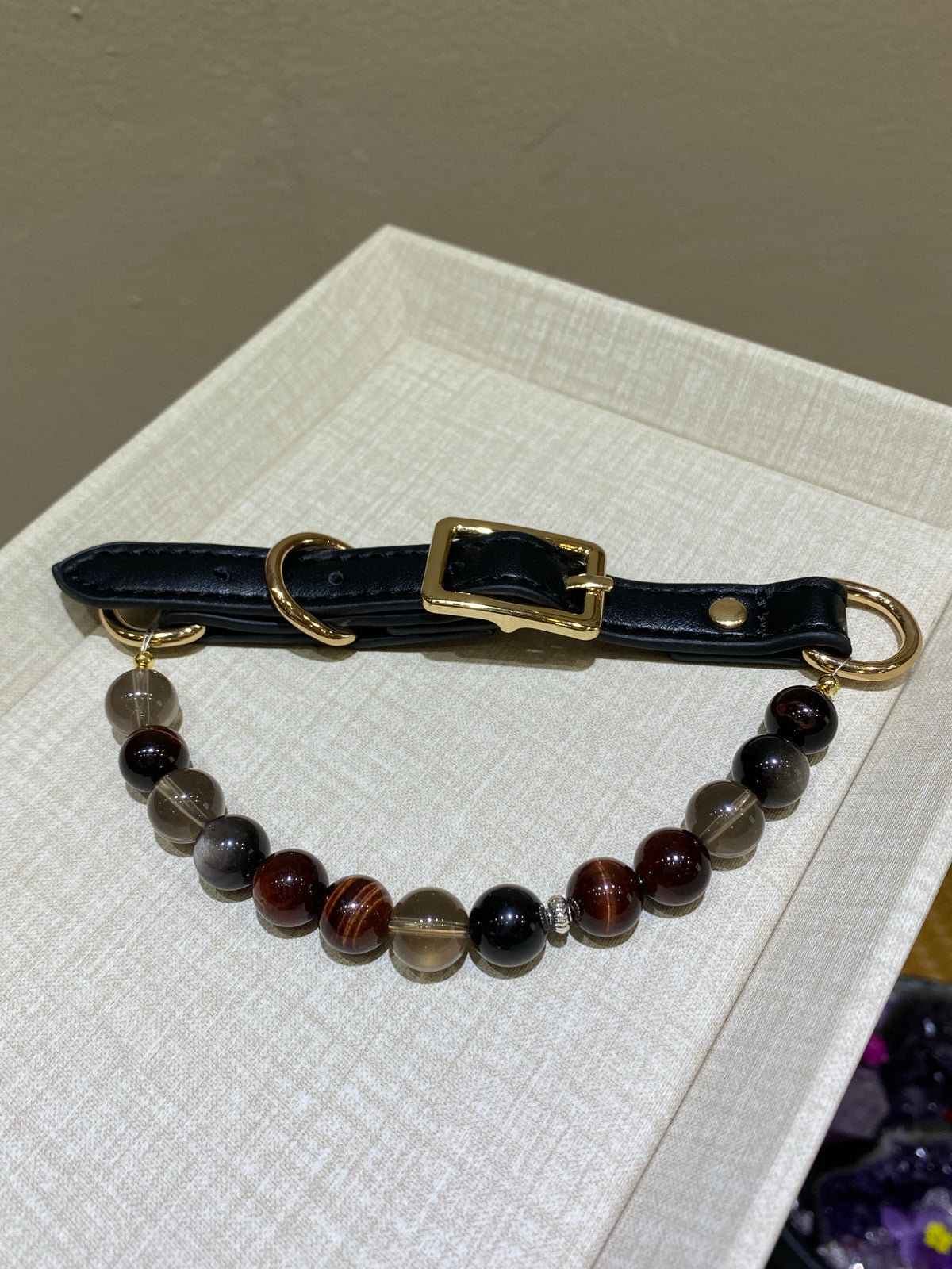 Smoky Ember crystal pet collar with deep brown, black and translucent beads on a neutral display tray