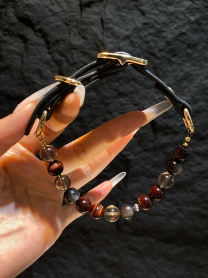 Hand-held close-up of dark red, smoky and black beads on Smoky Ember crystal pet collar