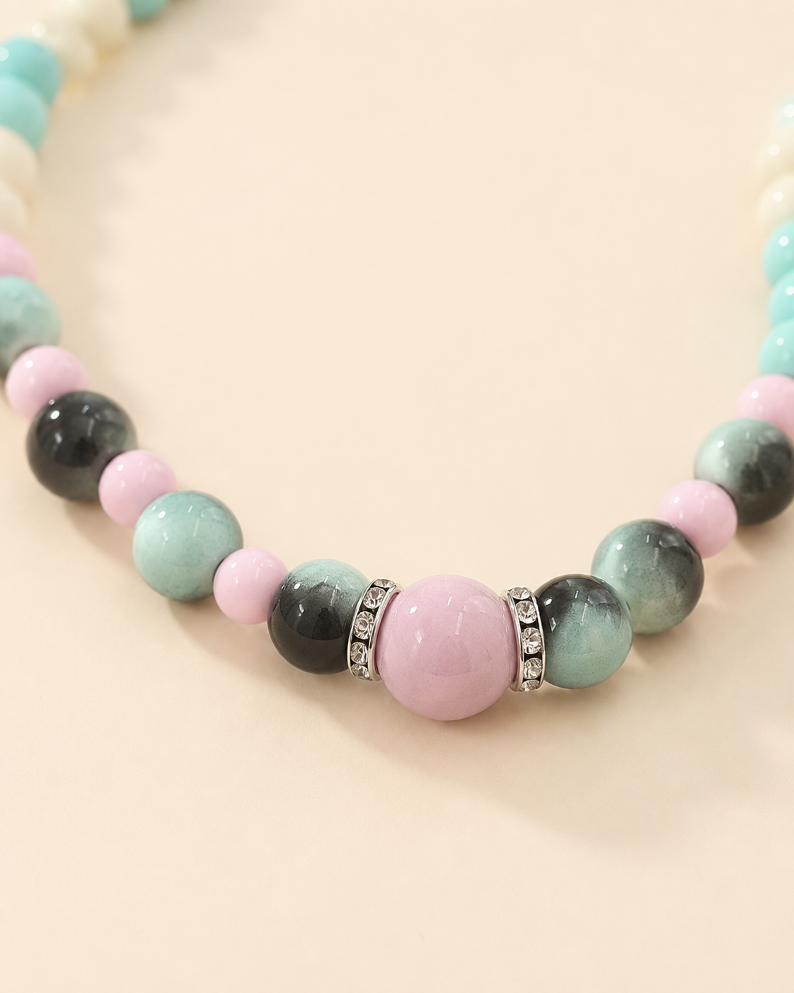 Close-up of pink centerpiece and gradient green beads on pet necklace