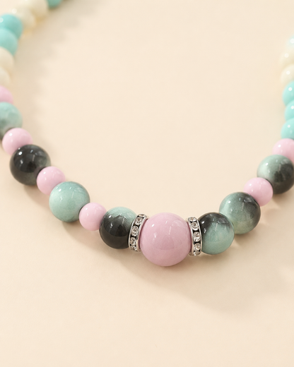 Close-up of pink centerpiece and gradient green beads on pet necklace