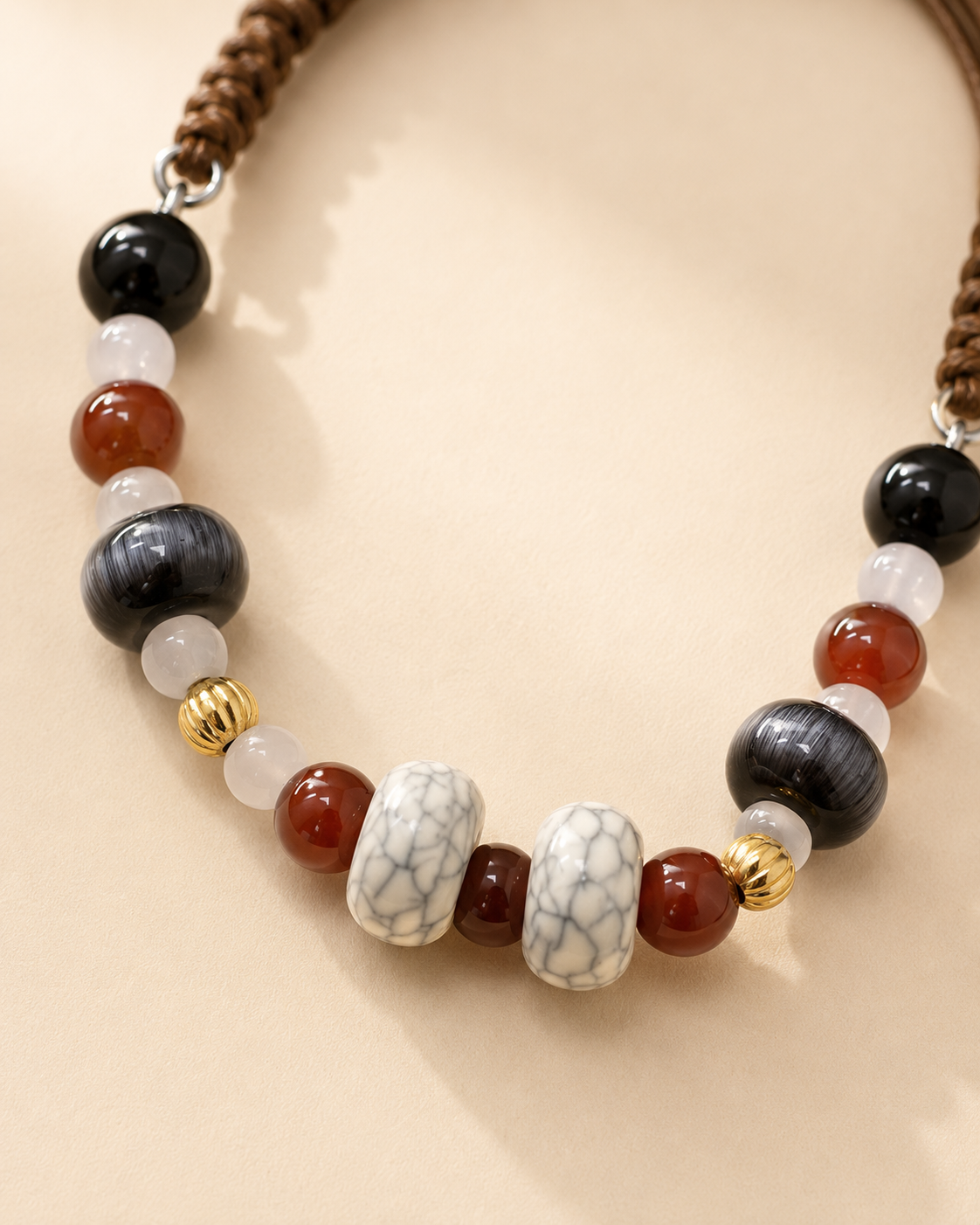 Close-up of black brown smoky and white marbled beads on pet necklace