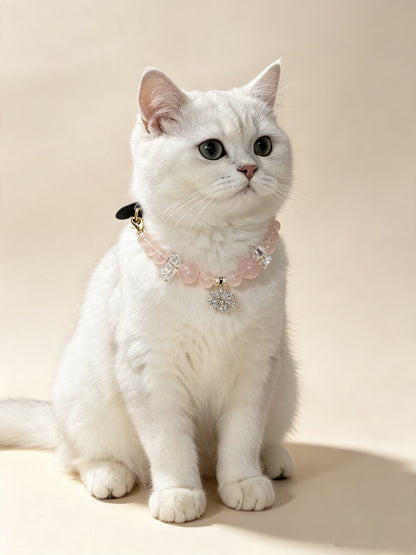 White cat wearing a Blush Snowflake crystal pet collar with pink beads and snowflake charm