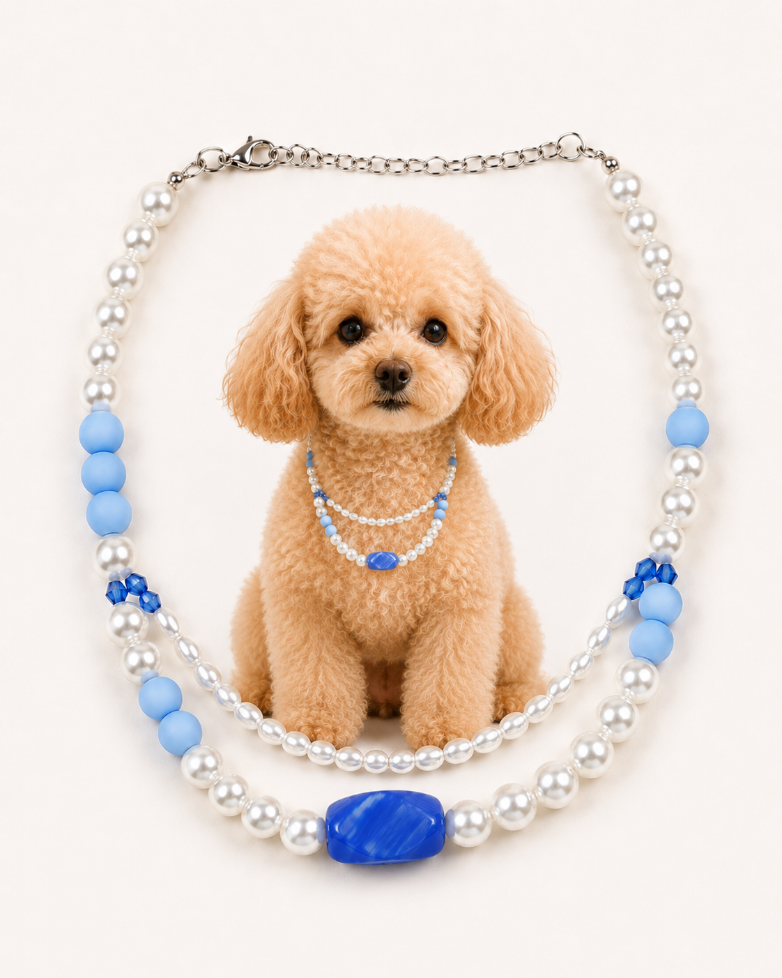 A decorative pet collar necklace featuring white faux pearls, light blue beads, and a large blue oval centerpiece, displayed around a small tan poodle on a plain light background.