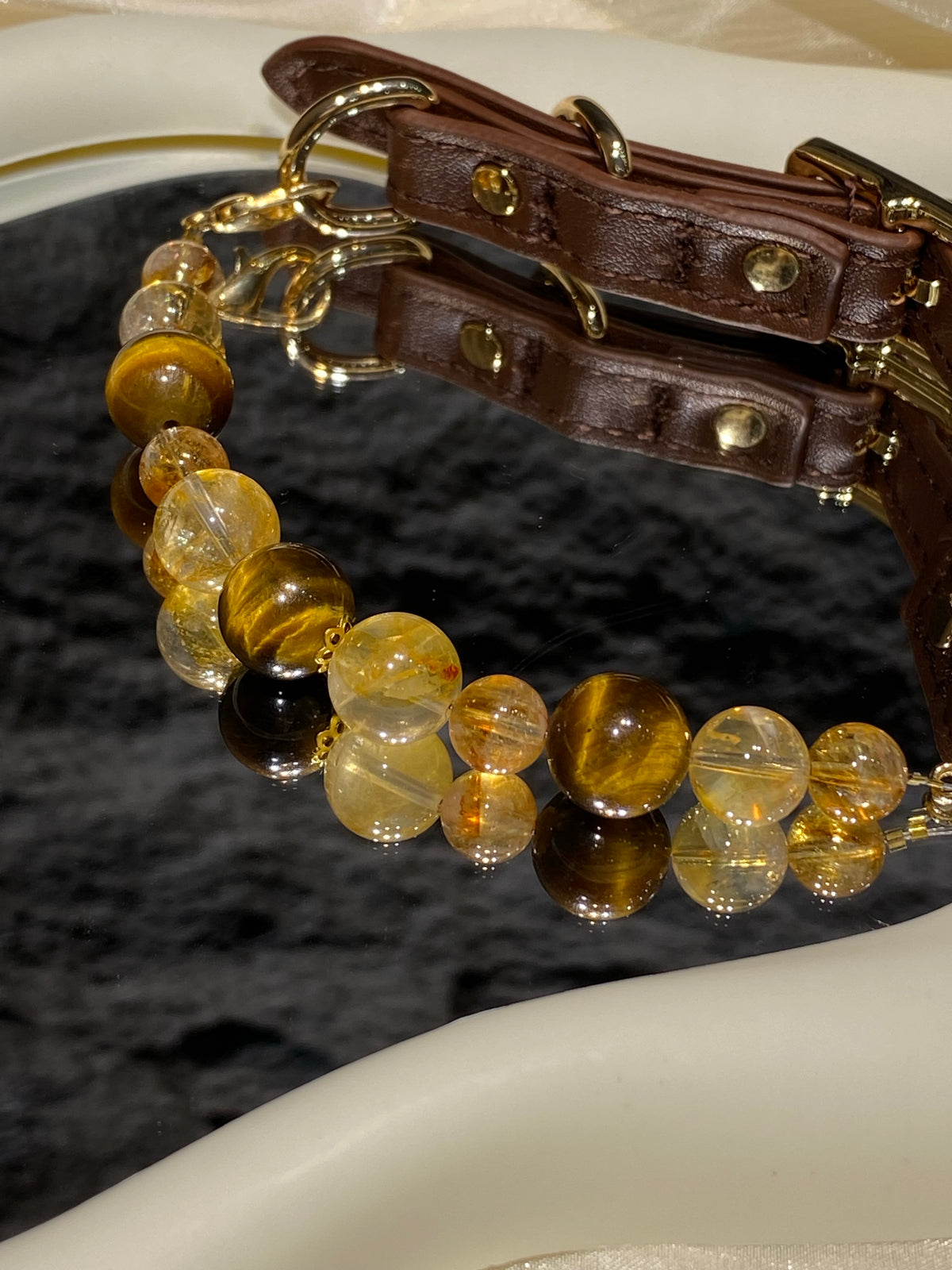 Close-up of amber, golden and striped brown beads on the Jinyao pet collar