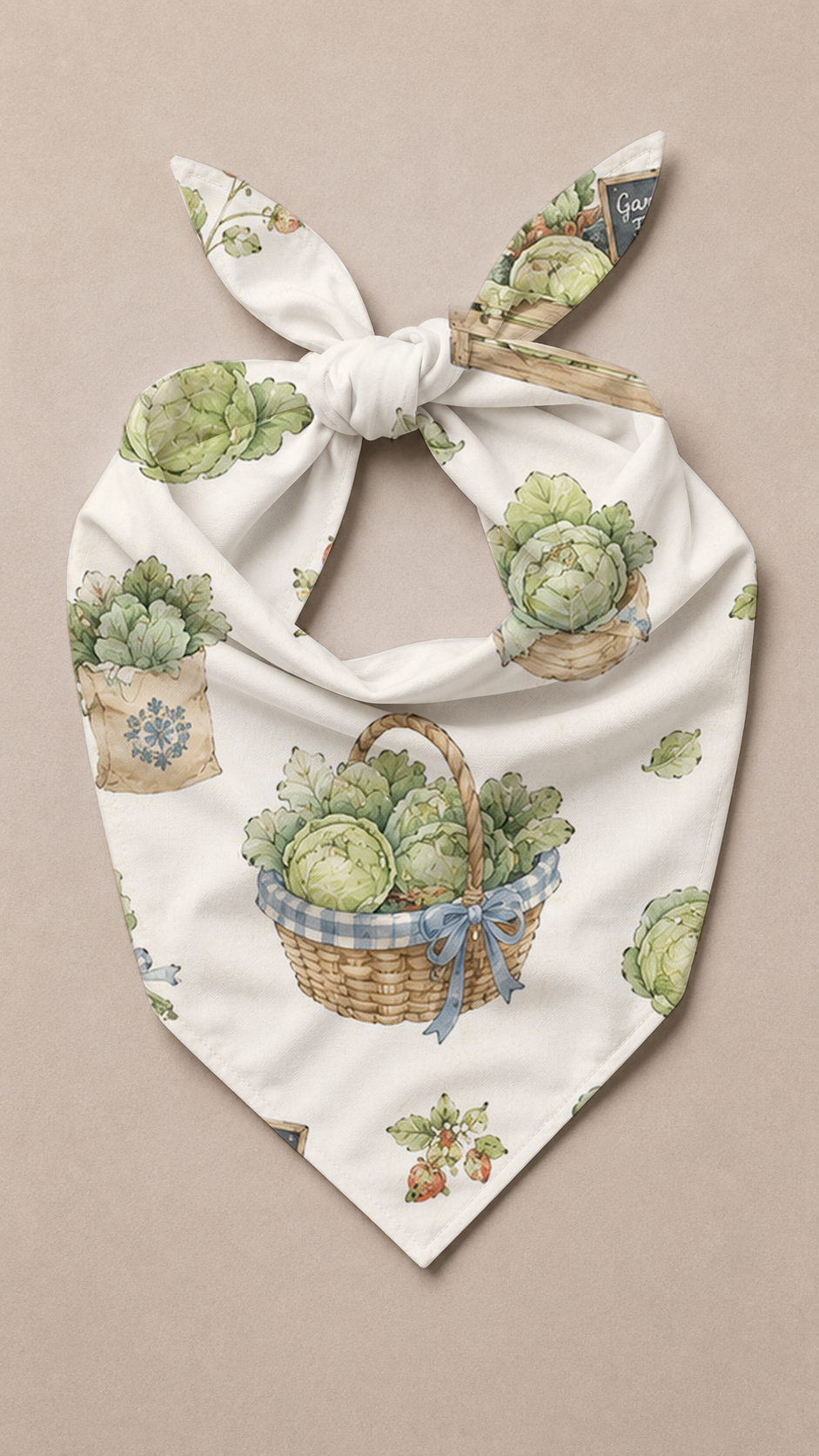 A white bandana-style pet scarf with a printed pattern of cabbage baskets, pots, and small plants, tied in a knot at the top on a neutral beige background.