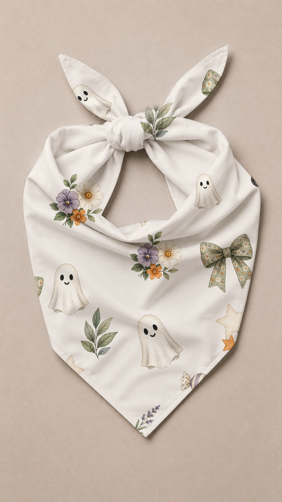 A white tie-on dog bandana featuring a cute ghost and floral pattern, displayed flat against a neutral beige background.