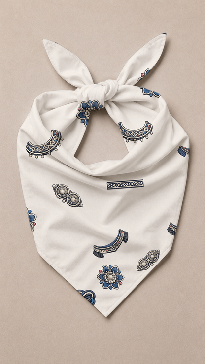 An off-white cotton bandana tie-on with a blue and gray paisley pattern, displayed flat on a neutral beige background.