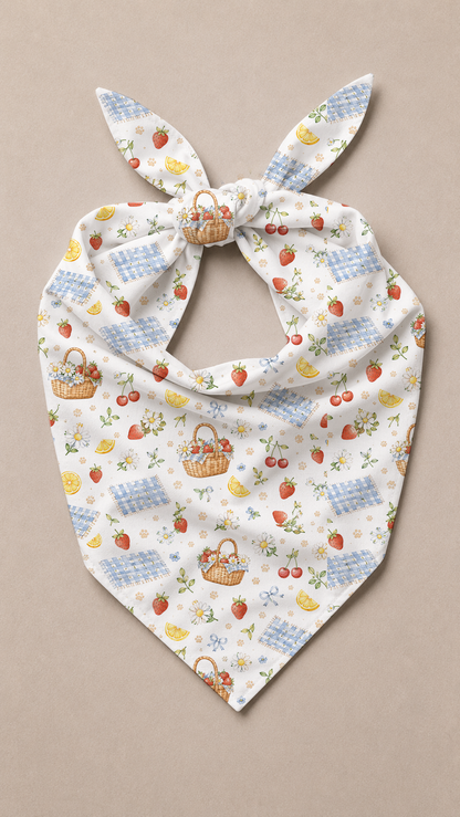 Flat lay view of a Picnic dog bandana with tiny picnic baskets, strawberries, cherries, and lemon slices.
