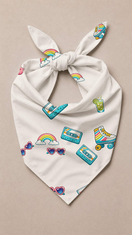 A white tie-front bandana or scarf featuring a colorful retro pattern of rainbows, cassette tapes, roller skate wheels, heart-shaped sunglasses, and a drink, displayed flat on a neutral beige background.